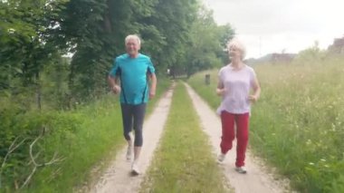 Aktif kıdemli erkek ve kadın daha iyi spor yapmak için koşuyorlar.