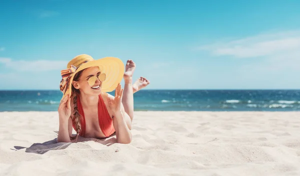 Mujer disfrutando de sus vacaciones junto al mar bronceándose en la arena de la playa — Foto de Stock