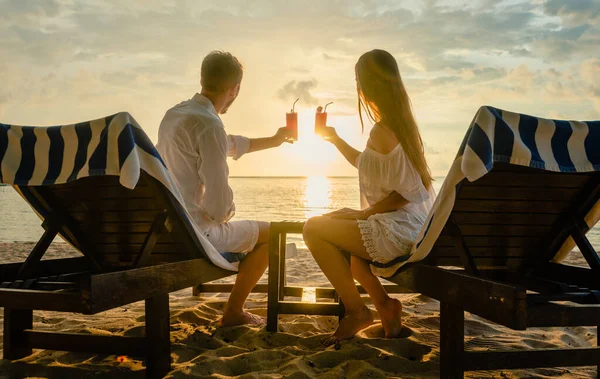 Para pijąca koktajle na plaży podczas wakacji lub miesiąca miodowego w tropikach — Zdjęcie stockowe