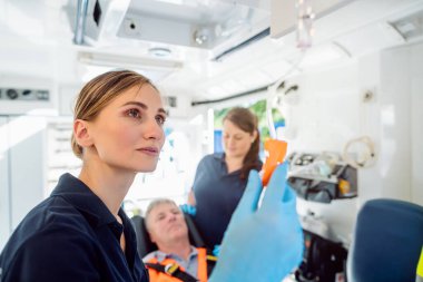 Ambulanstaki enjeksiyonla ilgilenen sağlık görevlisi.