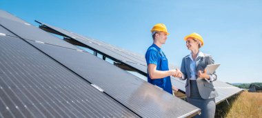 Güneş enerjisi santralinin inşaat işçisi ve yatırımcısı el sıkışıyor