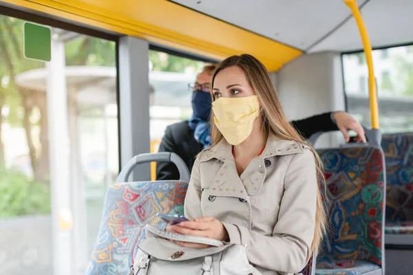 Люди в масках в автобусі використовують громадський транспорт — стокове фото