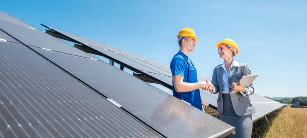 Працівник будівництва та інвестор сонячної електростанції трясуться руками — стокове фото