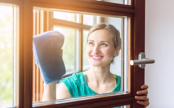 Belle femme qui nettoie les fenêtres au printemps — Photo