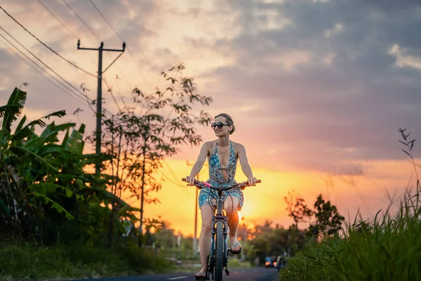 Woman having an excursion on her bike in tropical vacation