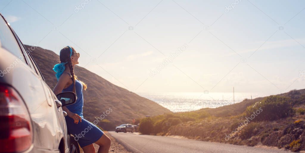 Woman on a road trip arriving with her car by the sea