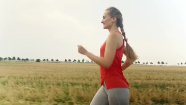 Donna che corre in campagna per una migliore forma fisica — Video Stock