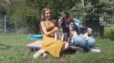 Kadın arkadaşlar hayvan barınağında köpeklerle oynuyorlar.