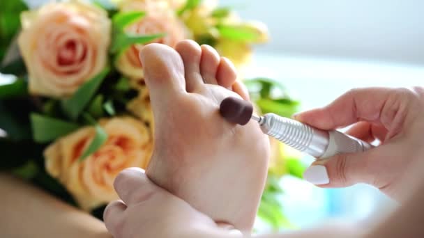 Mujer podólogo pulido alimentación de los hombres durante la pedicura