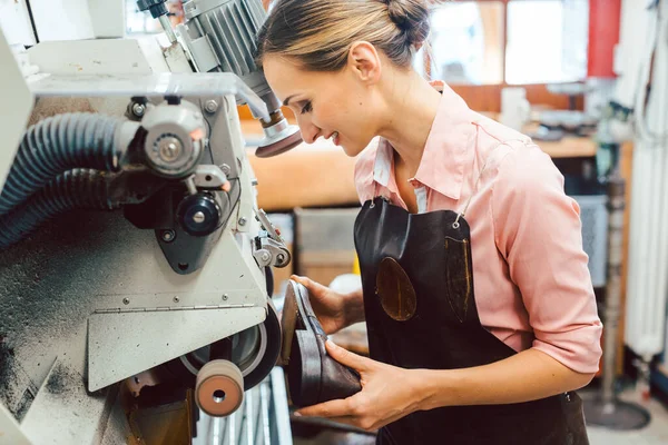 Női cipész, aki gépen dolgozik a cipőkészítő műhelyében. — Stock Fotó