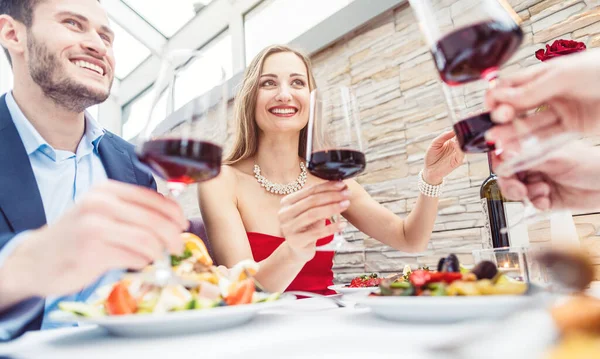 Amici in un ristorante elegante brindare con vino rosso italiano — Foto Stock