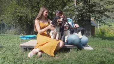 Hayvan barınağında köpeklerle eğlenen iki kız arkadaş.