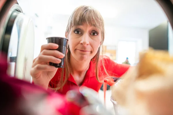 Wanita dengan cangkir kopi terlihat di mesin cuci — Stok Foto