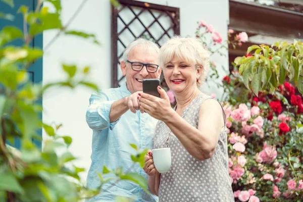 Abuelos haciendo videollamadas con sus nietos usando el teléfono — Foto de Stock