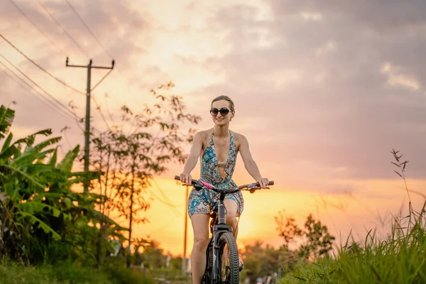 Kvinna som har en utflykt på sin cykel i tropisk semester — Stockfoto