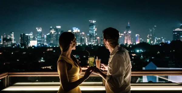 Par som tar en drink på takterrassen med utsikt över staden — Stockfoto