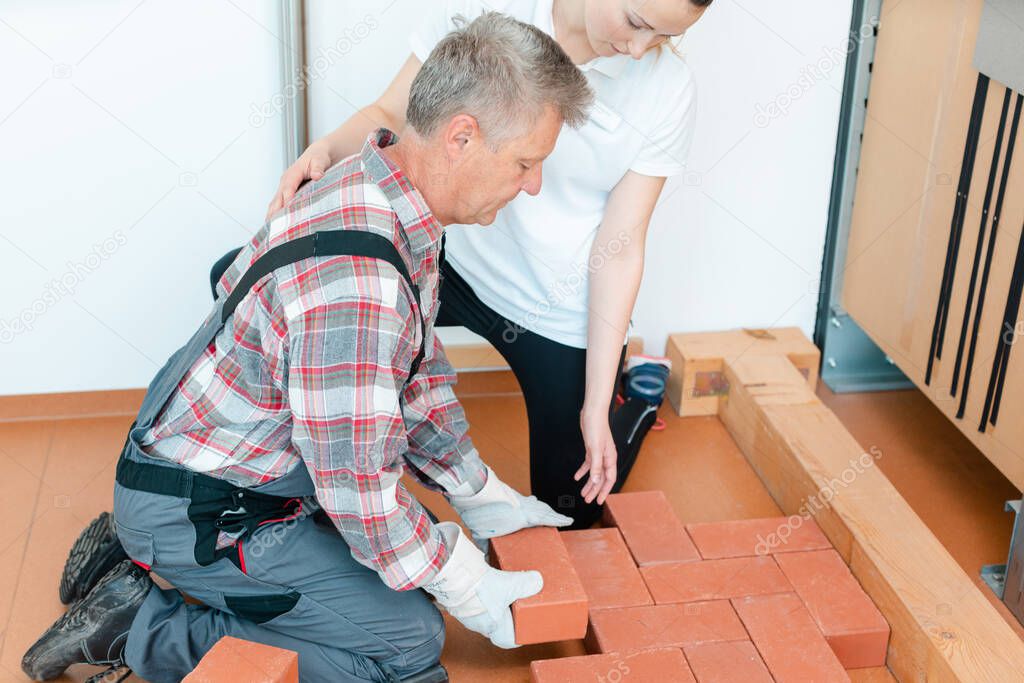 Worker in occupational therapy re-learning to lay bricks