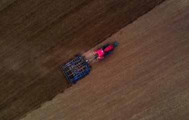 Toprağı açmak için tarlayı sürten traktörlü çiftçi.