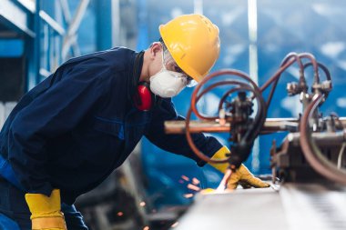 CNC plazma kesici kullanan Asyalı işçi