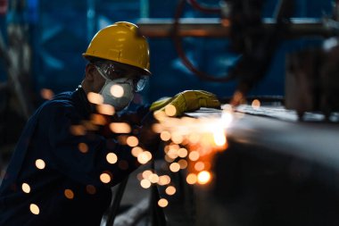 CNC plazma kesici kullanan Asyalı işçi
