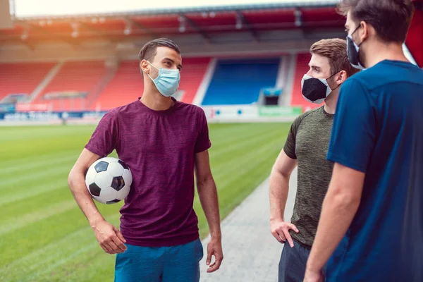 Les joueurs de football dans le stade de football pendant covid-19 portant des masques — Photo