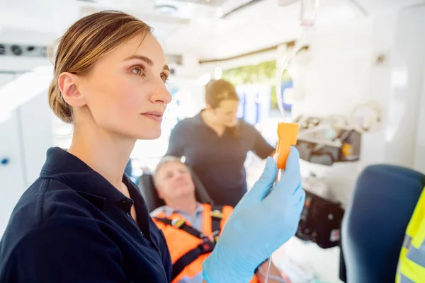 Paramédico se ocupa de la inyección de gota en una ambulancia —  Fotos de Stock