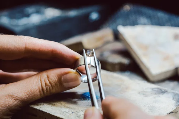 Joyero colocando una piedra preciosa con pinzas en un anillo —  Fotos de Stock