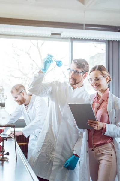 Equipe de cientistas durante a experiência no laboratório — Fotografia de Stock