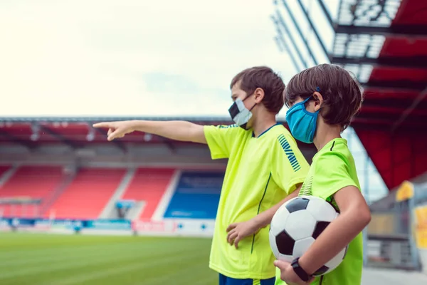 Dwóch chłopców chcących grać w piłkę nożną na stadionie podczas covid-19 — Zdjęcie stockowe