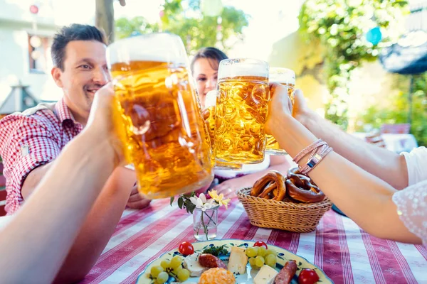 Anstoßen im bayerischen Biergarten — Stockfoto