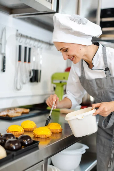 Confectioner working on sweet little cakes — Stock Photo, Image