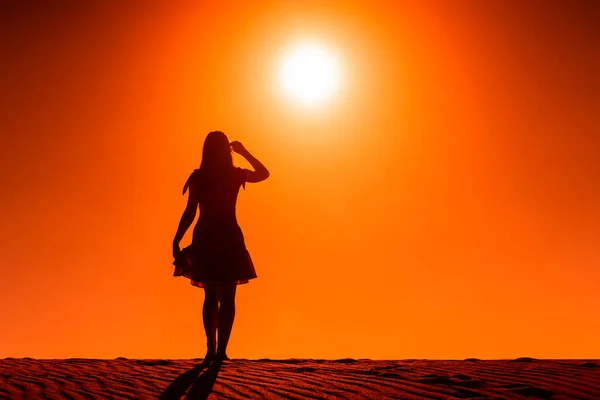 Sol ardiendo despiadadamente sobre una mujer de pie en un desierto —  Fotos de Stock