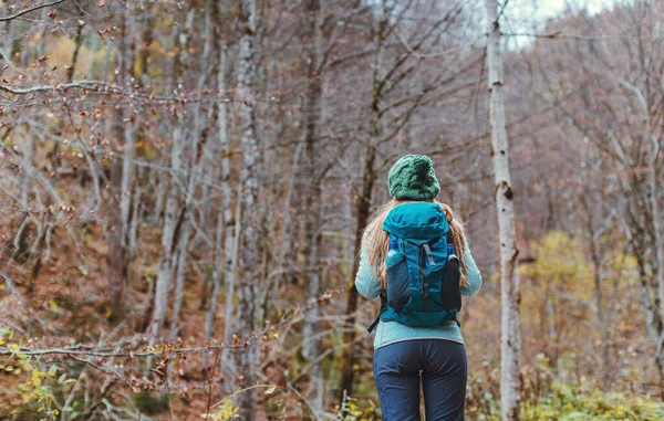 女人在秋天的树林里徒步旅行 — 图库照片