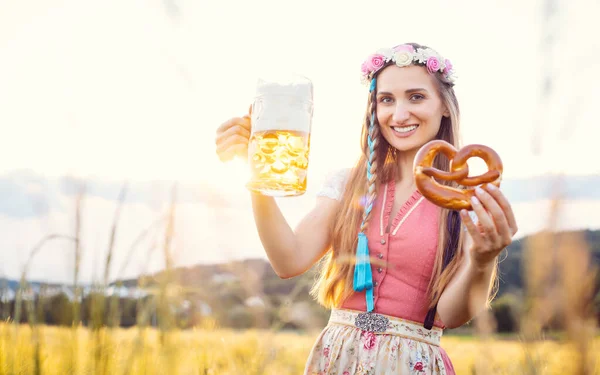 Femme bavaroise avec bière et bretzel dans un beau paysage — Photo