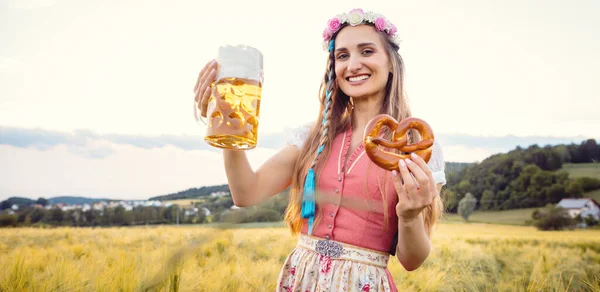 Happy Bavarian woman with beer and traditional food in summer — Stock Photo, Image