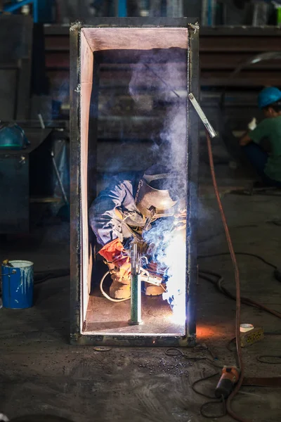 Soldadura do trabalhador de colarinho azul no interior de uma fábrica — Fotografia de Stock