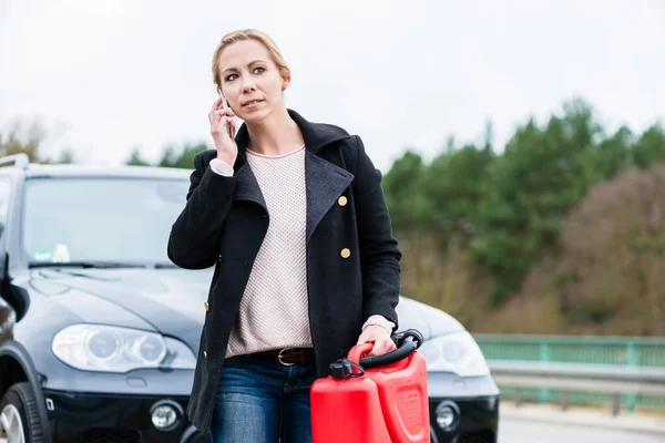 Woman out of gas with her car phoning for somebody to pick her up — Stock Photo, Image