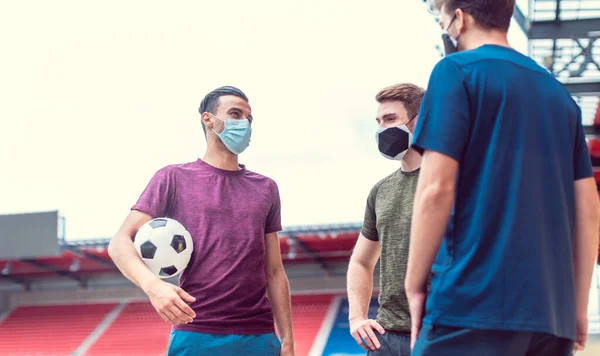 Jugadores de fútbol en el estadio de fútbol durante el covidio-19 con máscaras — Foto de Stock