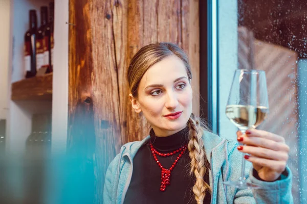 Приваблива жінка насолоджується білим вином в магазині — стокове фото