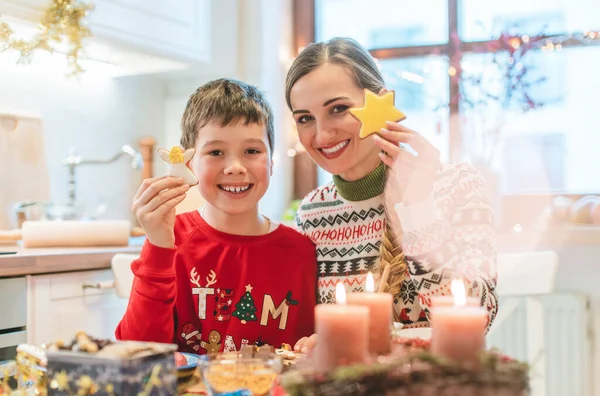 Niño y su madre con galletas de Navidad en la cocina en casa — Foto de Stock