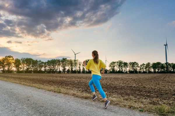 Vrouw rent of jogt over een pad op het platteland — Stockfoto