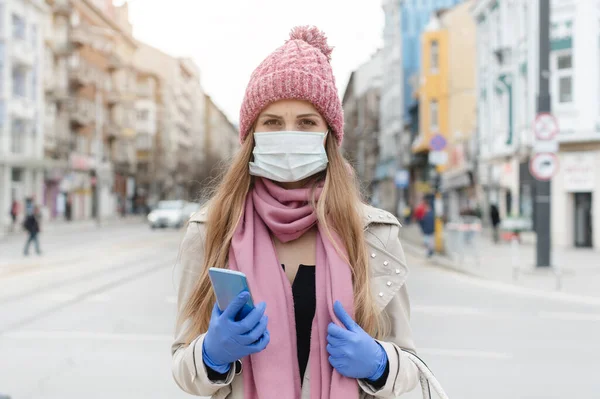 Mujer preocupada de pie en la ciudad de encierro con máscara médica — Foto de Stock