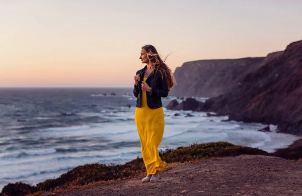 Vrouw op een zonsondergang strand met de wind in haar haar — Stockfoto