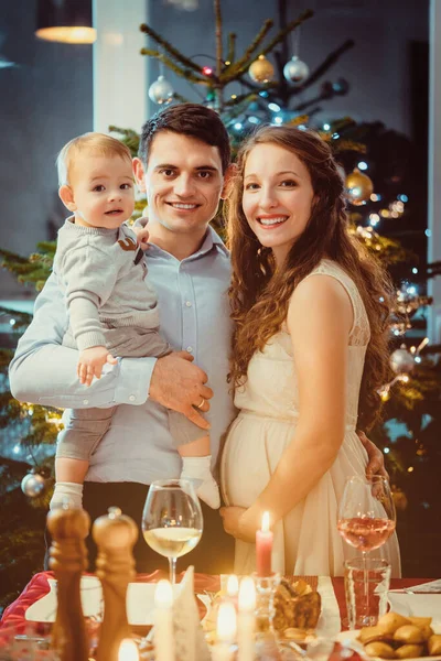 Οικογένεια με νήπιο και έγκυο γυναίκα γιορτάζει τα Χριστούγεννα — Φωτογραφία Αρχείου