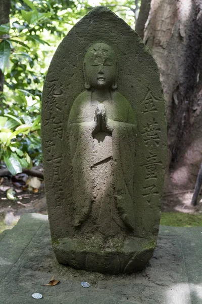 Tokyo, Japan -  Buddha statue with sun light in the garden of the Nezu museum