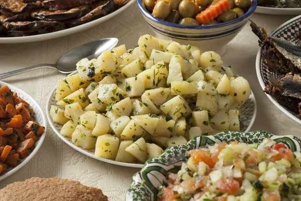 Moroccan meal with a variety of dishes with fresh cooked sardines, vegetables and bread