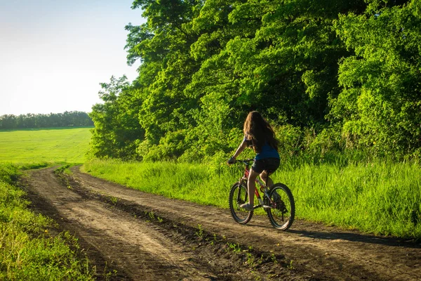 Młoda Dziewczyna jazda na rowerze w kraju road — Zdjęcie stockowe