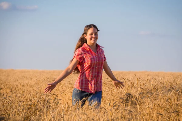 Young girl walking on field with ripe wheat — Stock Photo, Image