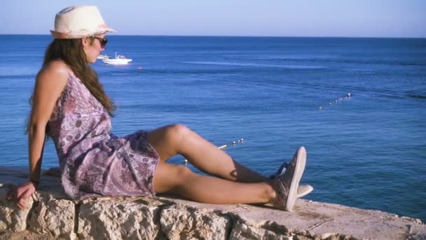 Девушка на побережье ищет лазурное море — стоковое видео