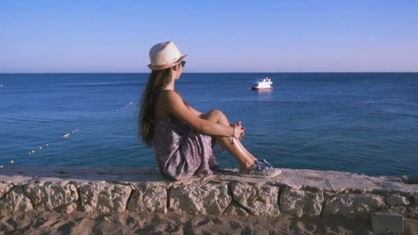 Chica en la costa mirando al mar azul — Vídeos de Stock